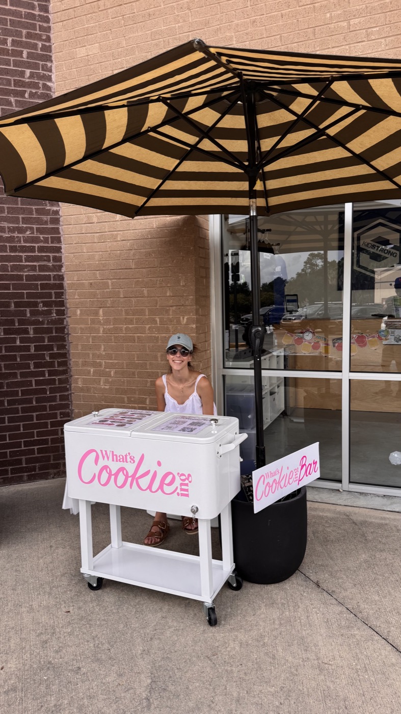 The What's Cookie-ing cart under a striped umbrella in front of a storefront