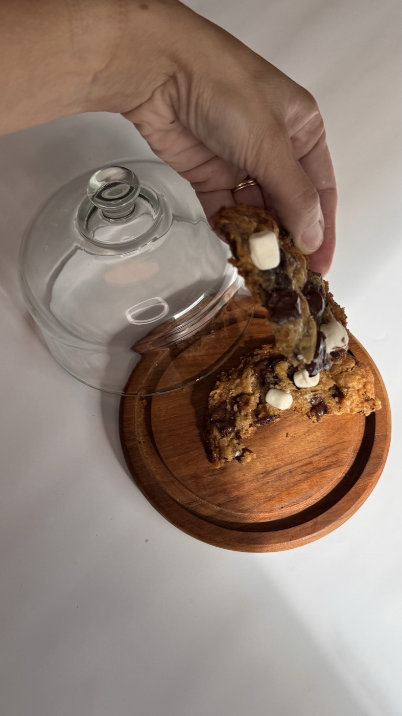 A S'mores cookie broken in half over a wooden board